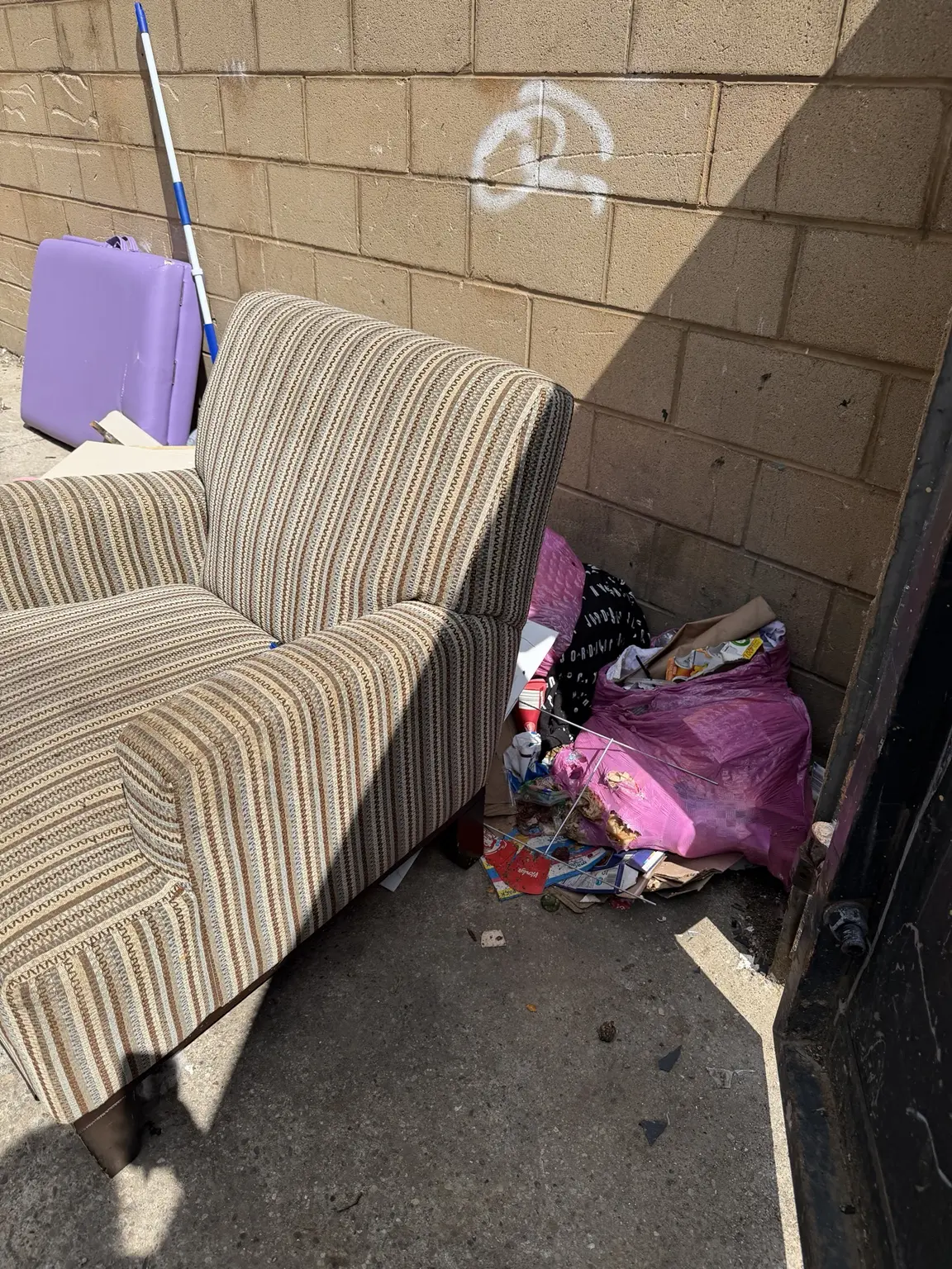 A usable armchair in the Waggoner Park bulk area surrounded by loose trash and litter